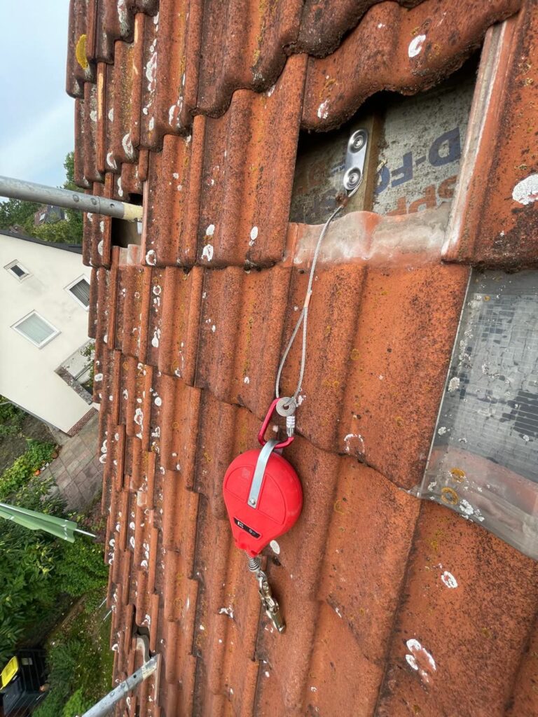 Höhensicherungsgerät am fest gesetzten Anschlagpunkt auf dem Dach
